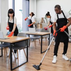 People of cleaning service cleans tables, floor, and panoramic windows.